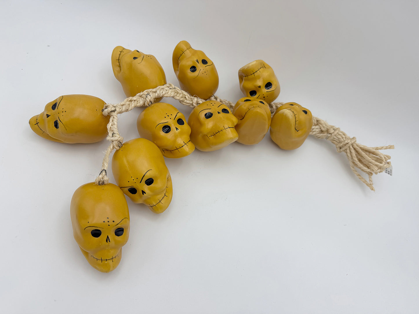 Ristra de mecate con 10 cráneos de cerámica color oro