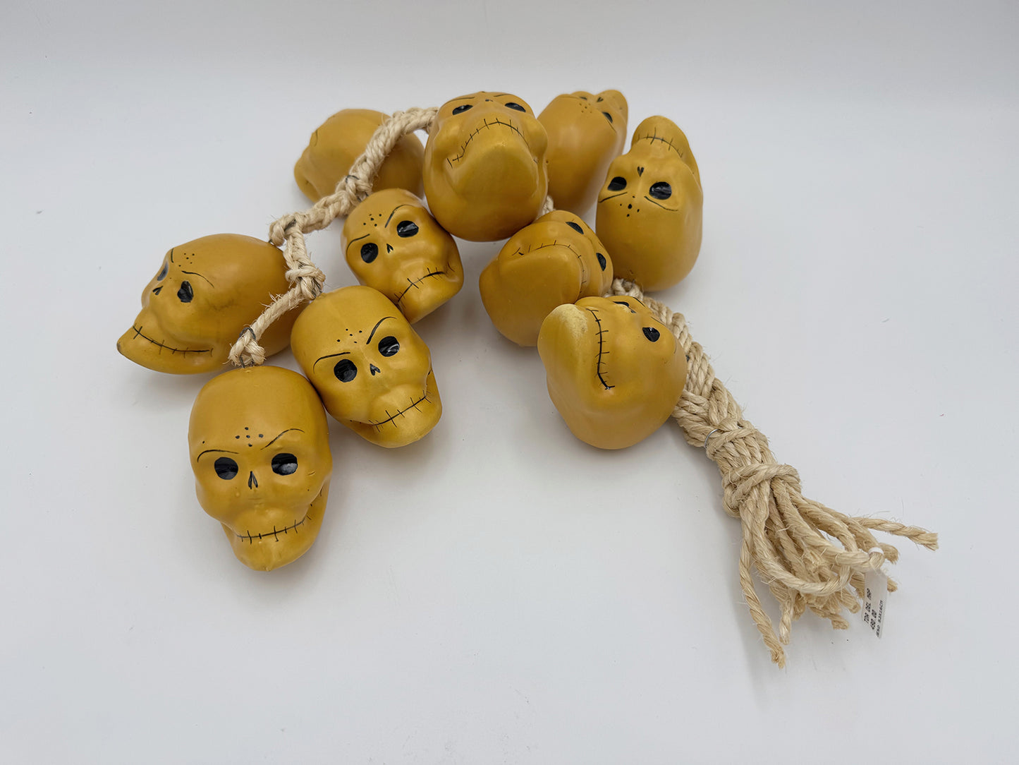 Ristra de mecate con 10 cráneos de cerámica color oro