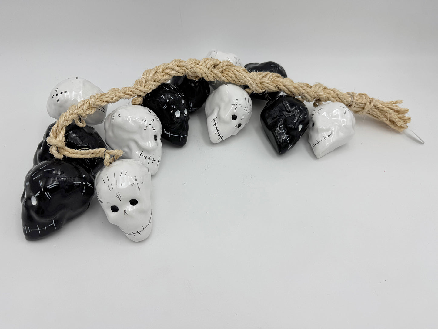 Ristra de mecate con 12 cráneos de cerámica blanco y negro